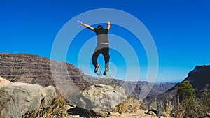 Happy man jumping in the mountain peak