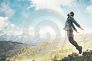 Happy Man jumping at mountains to clouds sky