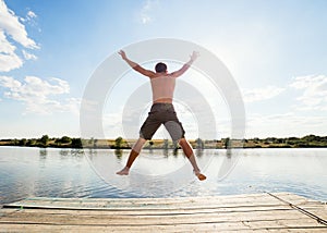 Happy man jumping on pier