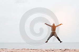 Happy man jumping at tropical sand beach background. Freedom feel good and summer vacation concept