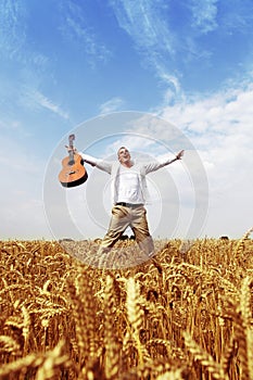 Happy man jumping in a wheat field