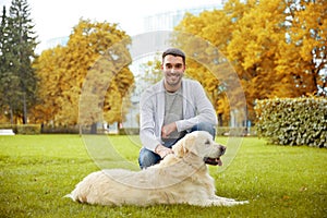 Happy man with labrador dog in autumn city park