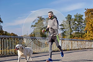 Happy man with labrador dog running outdoors