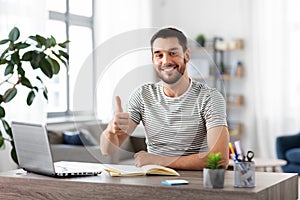 Happy man with laptop working at home office