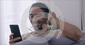Happy man listening to music with headphones online. Male relaxing and enjoying his favourite songs. Person listening to