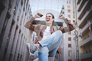 Happy man listening to music with headphones from a smartphone on the street.