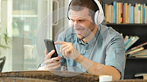 Happy man listening to music on phone in a bar