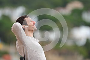 Happy man listening to music with wireless earbuds