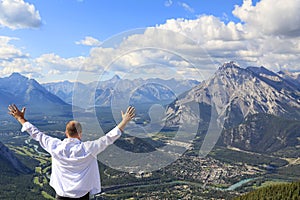 Happy man looking at a panorama of a small town Banff in a Bow river valley