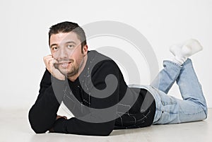 Happy man lying on wooden floor