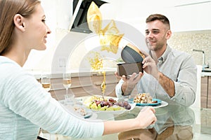 Happy man making gift for beloved woman