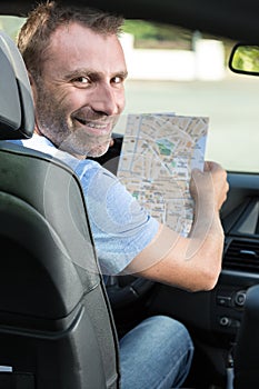 happy man with map in car