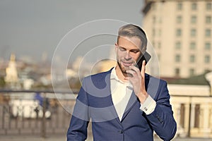 Happy man with mobile phone on sunny terrace. Businessman use smartphone with smile. Great business news. Business