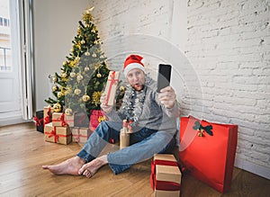 Happy man with mobile phone on video call celebrating christmas with family at home in lockdown