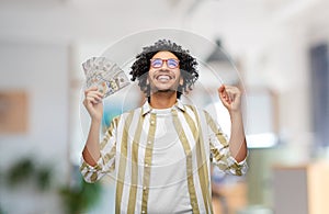 happy man with money celebrating success at office