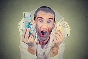 Happy man with money euro banknotes ecstatic celebrates success photo