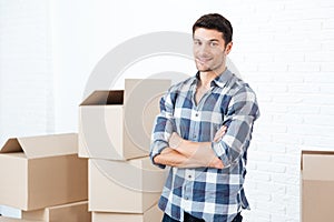 Happy man moving in carrying carton boxes