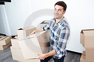 Happy man moving in and carrying carton boxes
