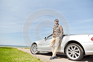 Happy man near cabriolet car outdoors