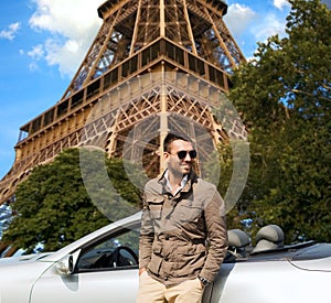 Happy man near cabriolet car over eiffel tower