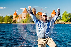 Happy man near castle and lake