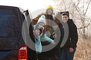 Happy man near modern car with his family