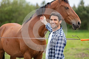 happy man next to horse at fence