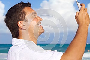 Happy man with phone on the beach