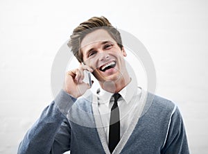 Happy man, phone call and laughing for funny joke, conversation or meme on a gray studio background. Face of young