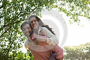 Happy man piggybacking woman at park