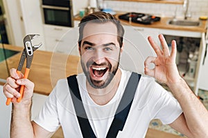 Happy man plumber showing okay gesture