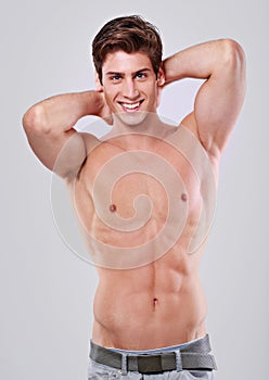 Happy man, portrait and confidence with muscular body in fitness, health or wellness on a gray studio background