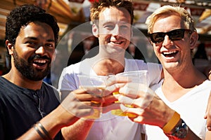 Happy man, portrait and friends cheers at music festival, bar or event for summer party or DJ concert. Male person or