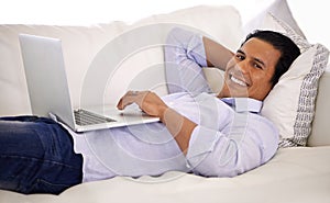 Happy man, portrait and laptop and relax on sofa for remote work, email or communication at home. Handsome businessman