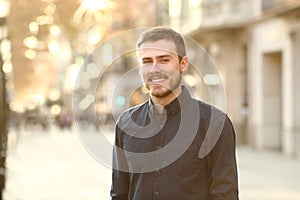 Happy man is posing in the street looking at camera