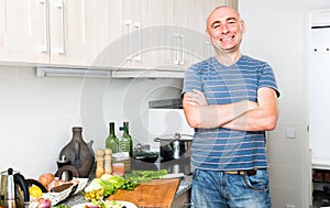 Happy man in the prime of life in kitchen prepared salads