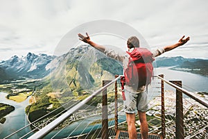 Happy man raised hands enjoying aerial mountains