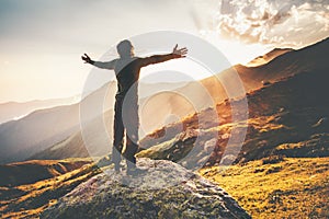 Happy Man raised hands at sunset mountains