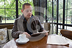 A happy man reading an ebook in a coffee shop