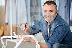 happy man reading instructions to assemble furniture