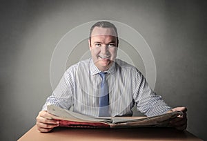 Happy man reading the newspaper