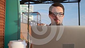 Happy man is relaxing alone with notebook on open veranda