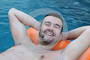 Happy man relaxing in swimming pool