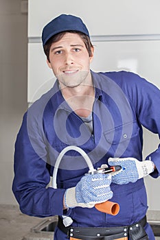 Happy man repairing a pipe