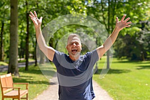 Happy man running in park on sunny day