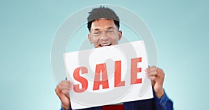 Happy, man and sale poster in studio with dance for advertising store promotion or discount deal on blue background