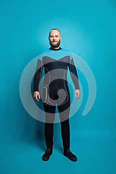 Happy man scuba diver standing on blue background