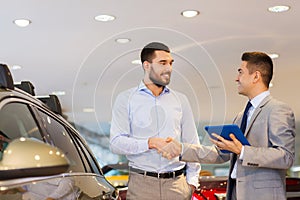 Happy man shaking hands in auto show or salon