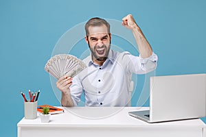 Happy man in shirt work at desk with pc laptop isolated on blue background. Achievement business career concept. Mock up