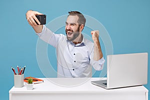 Happy man in shirt work at desk with pc laptop isolated on pastel blue background. Achievement business career concept